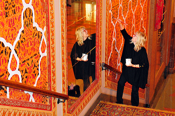 A women touched up the paint in the historic Bijou Theater