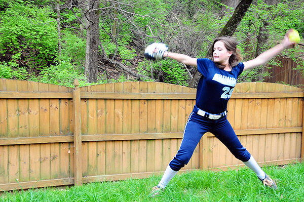 A teenager gets ready to throw a pitch